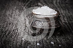 sea Ã¢â¬â¹Ã¢â¬â¹salt in a large antique salt shaker on old wooden table